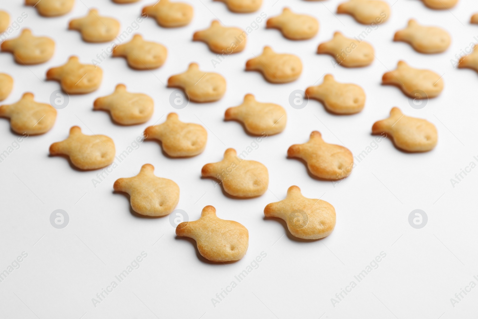 Photo of Delicious goldfish crackers on white background, closeup