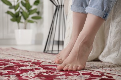 Photo of Woman on carpet with pattern at home, closeup. Space for text