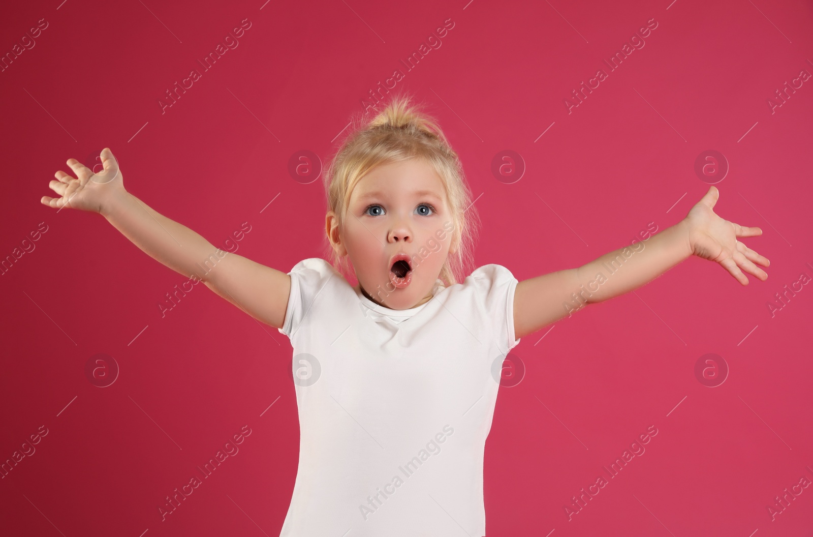 Photo of Portrait of emotional little girl on pink background