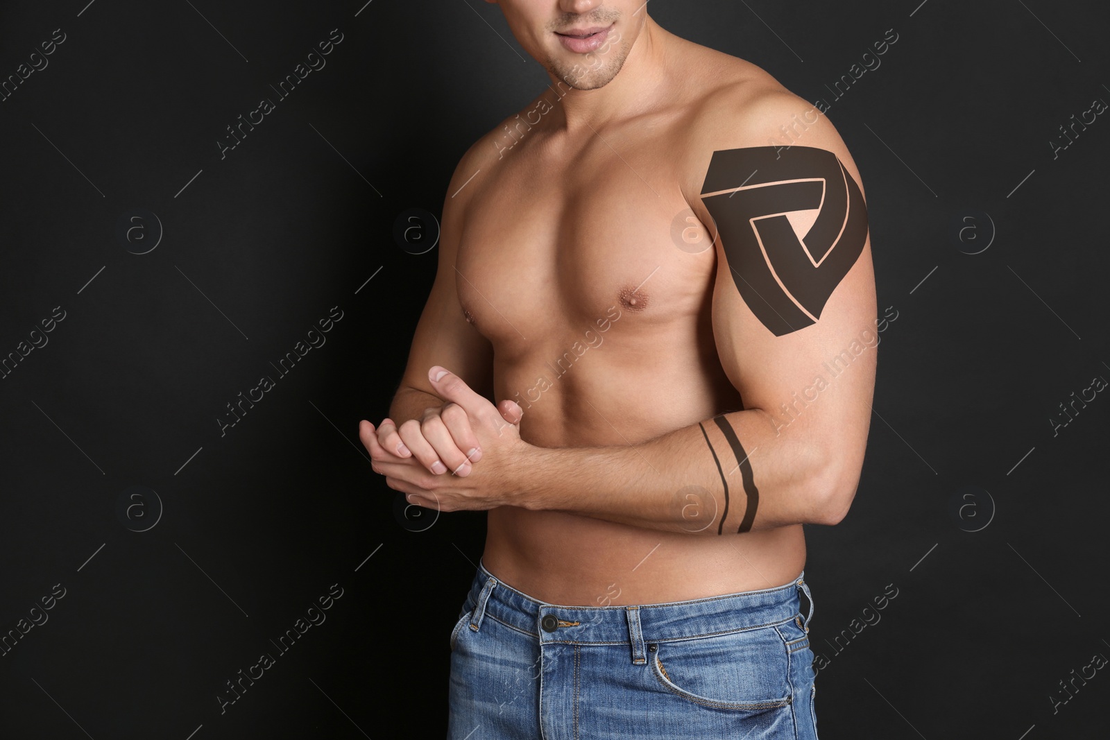 Image of Man with beautiful tattoo sketches on black background, closeup