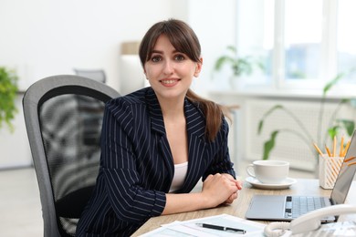 Photo of Portrait of smiling secretary at table in office