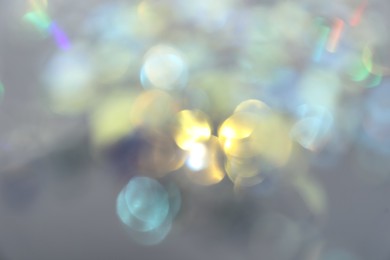 Blurred view of shiny lights on light background. Bokeh effect