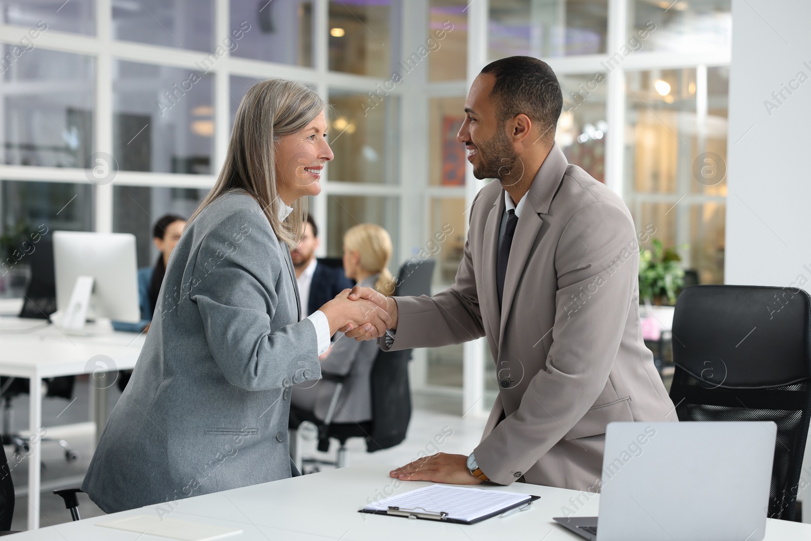 Photo of Lawyer shaking hands with client in office, selective focus