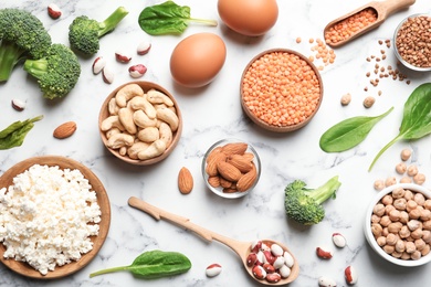 Photo of Set of natural food high in protein on marble background, top view
