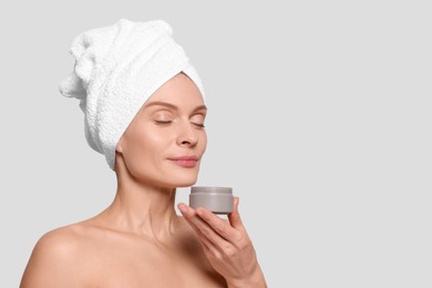 Photo of Woman with jar of body cream on white background, space for text
