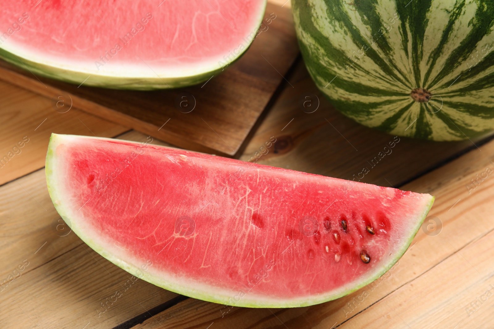 Photo of Yummy watermelon slice on wooden table, closeup