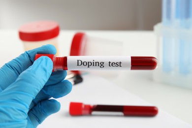Photo of Doctor holding test tube with blood sample, closeup. Doping control