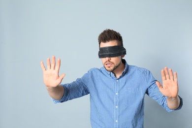 Photo of Man with black blindfold on grey background