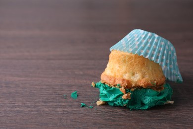 Photo of Dropped cupcake with cream on wooden table, closeup. Troubles happen