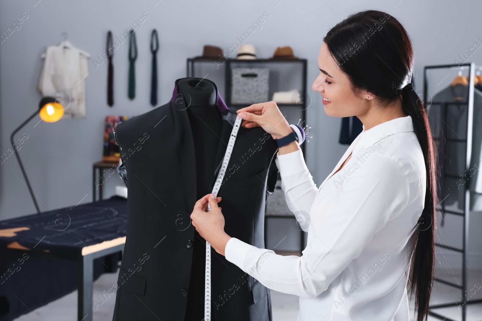 Photo of Professional dressmaker making suit jacket in atelier