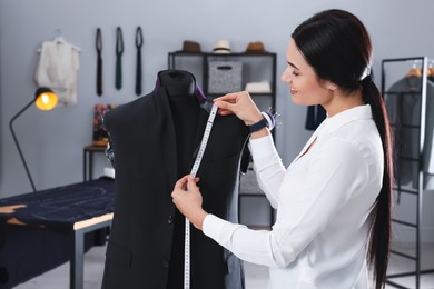 Professional dressmaker making suit jacket in atelier