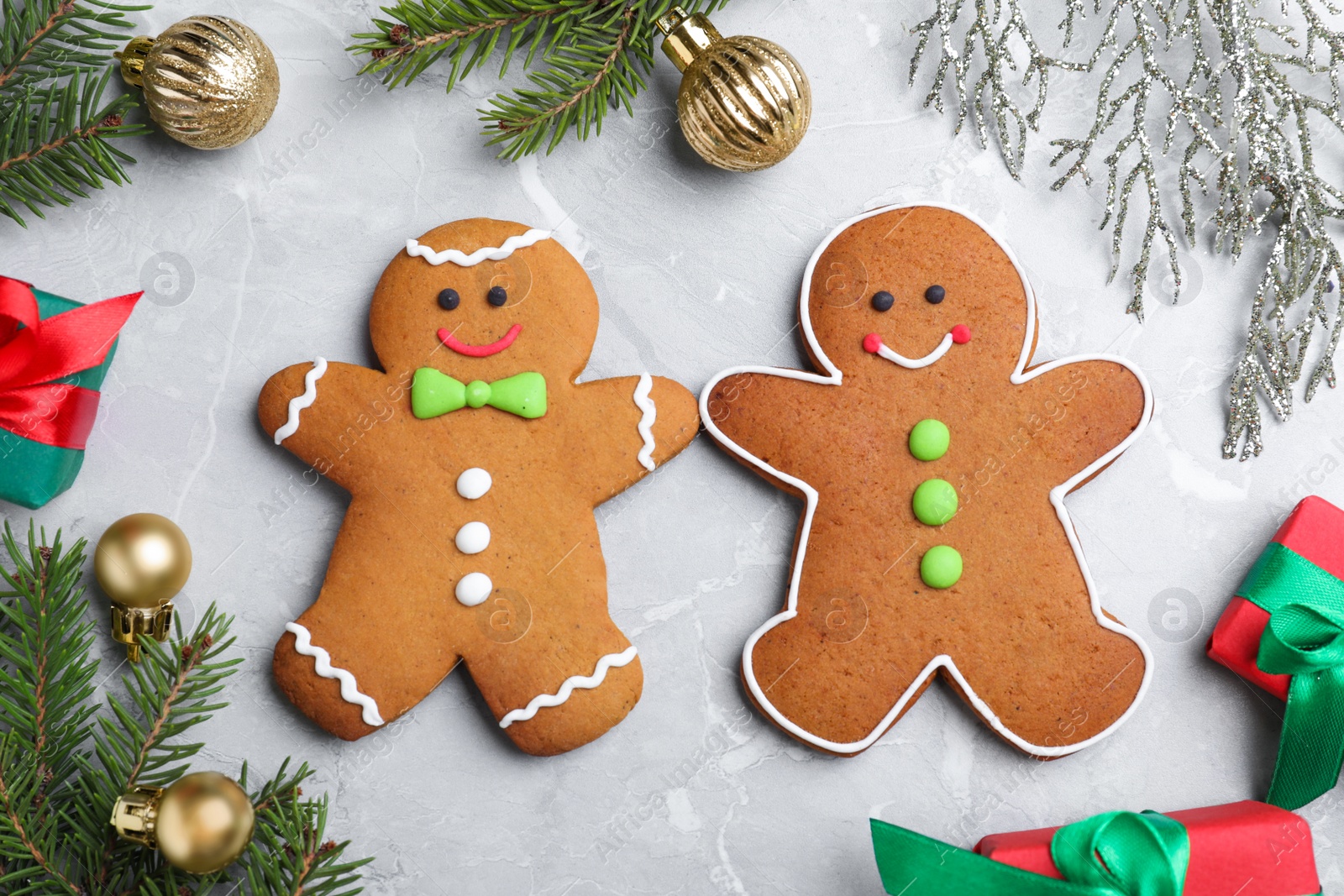 Photo of Flat lay composition with gingerbread people on light  grey marble table