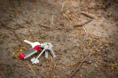 Photo of Keys on ground outdoors, space for text. Lost and found