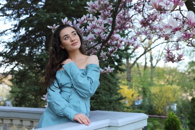 Photo of Beautiful woman near blossoming magnolia tree on spring day