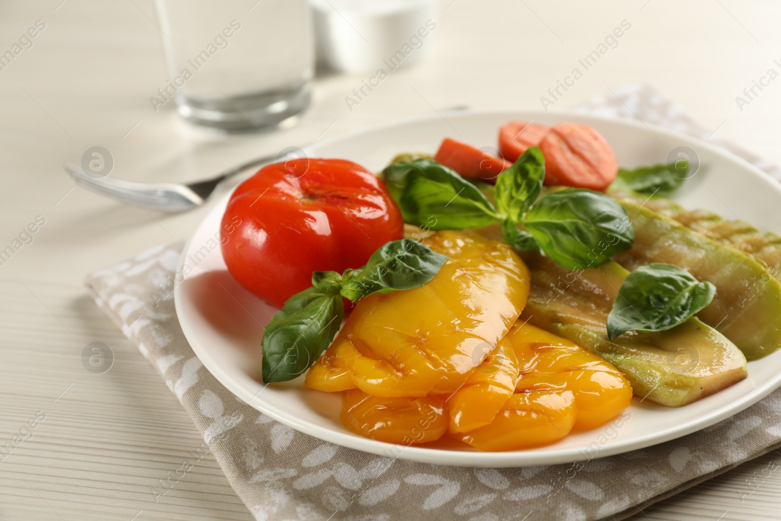 Photo of Delicious grilled vegetables with basil on white wooden table, closeup