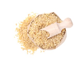 Photo of Paper bag and scoop with raw bulgur isolated on white, top view
