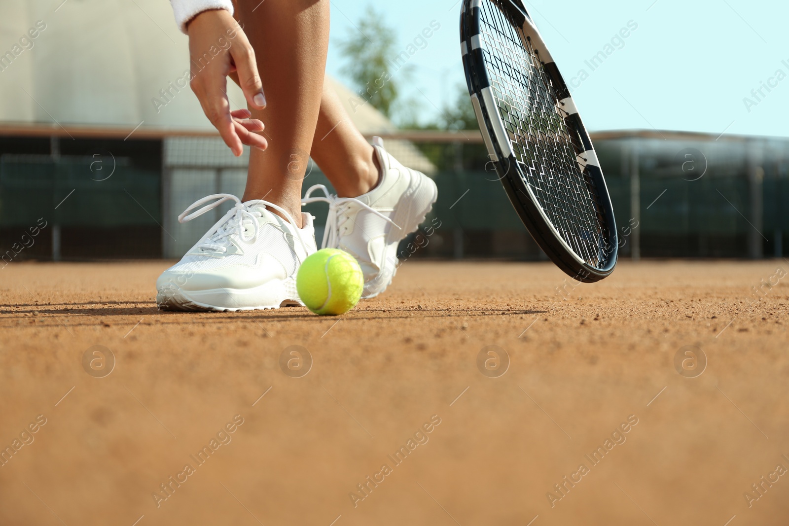 Photo of Sportswoman playing tennis at court on sunny day, closeup