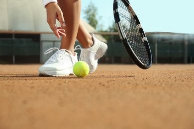 Sportswoman playing tennis at court on sunny day, closeup