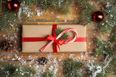 Photo of Flat lay composition with gift box and Christmas decor on wooden table