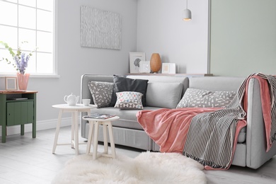 Photo of Cozy living room interior with comfortable sofa and elegant table