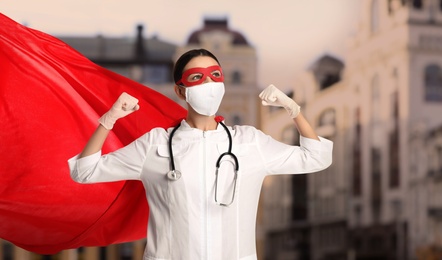 Image of Doctor dressed as superhero on city background. Medical workers fighting with dangerous diseases