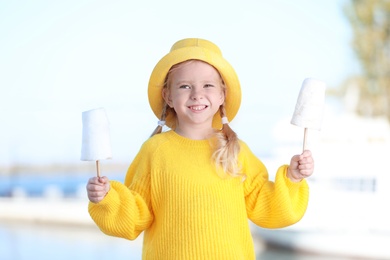 Cute little girl with cotton candies outdoors