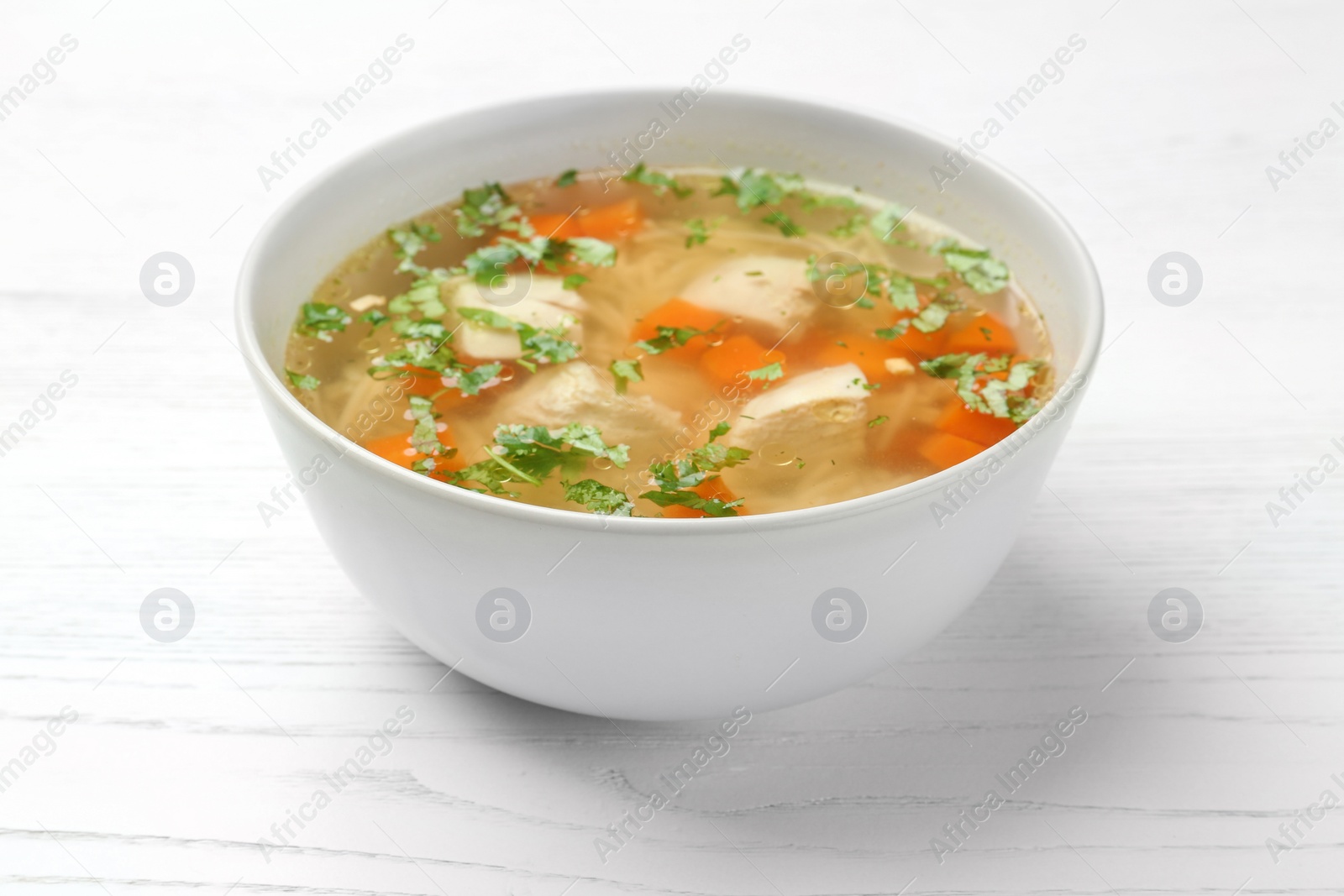 Photo of Bowl with fresh homemade chicken soup on wooden table