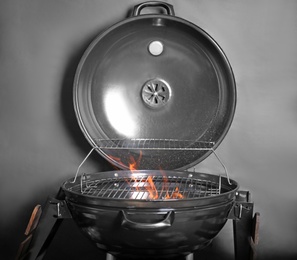 Photo of New modern barbecue grill with coals on black background