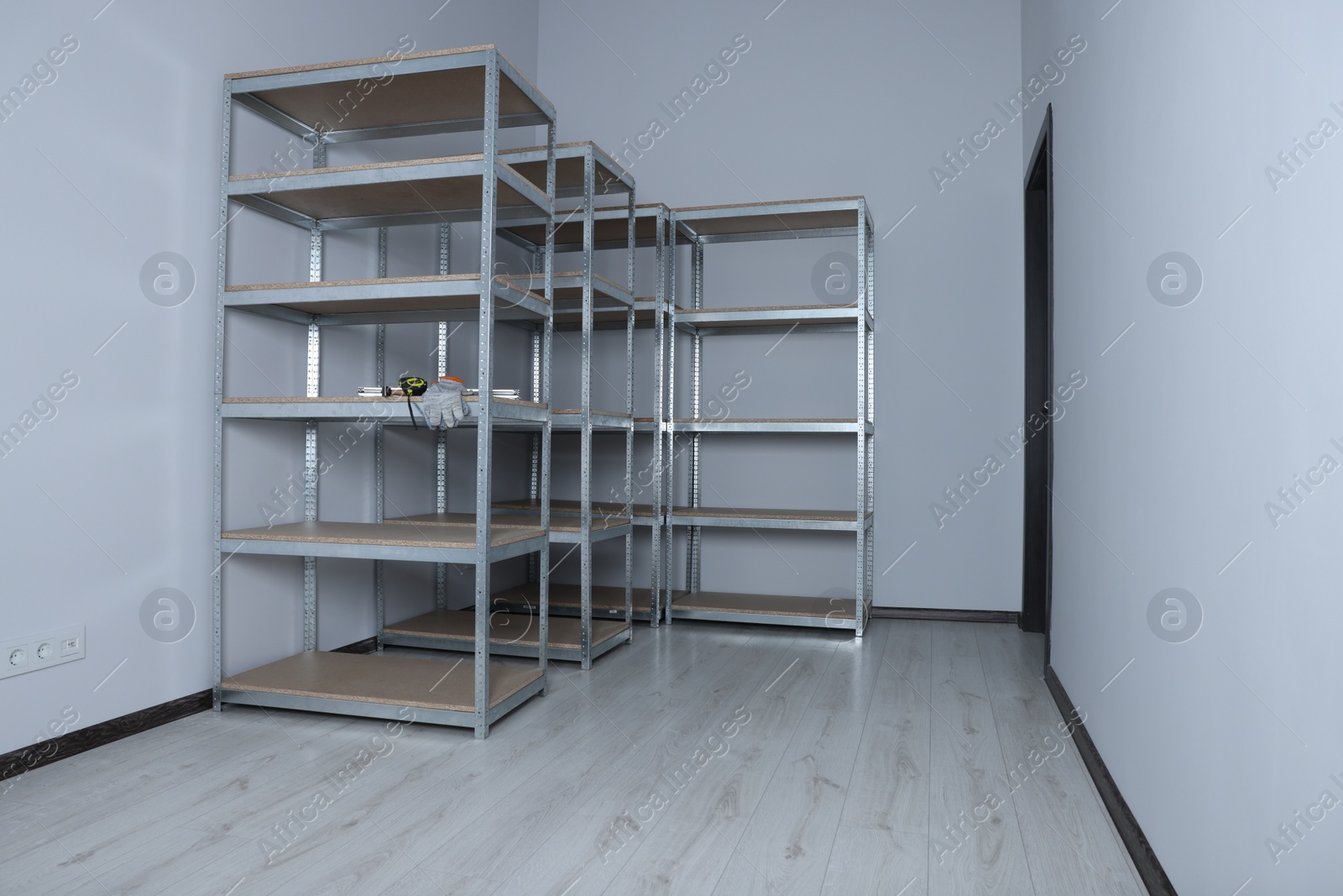 Photo of Office room with white walls and metal storage shelves