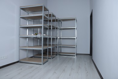 Photo of Office room with white walls and metal storage shelves