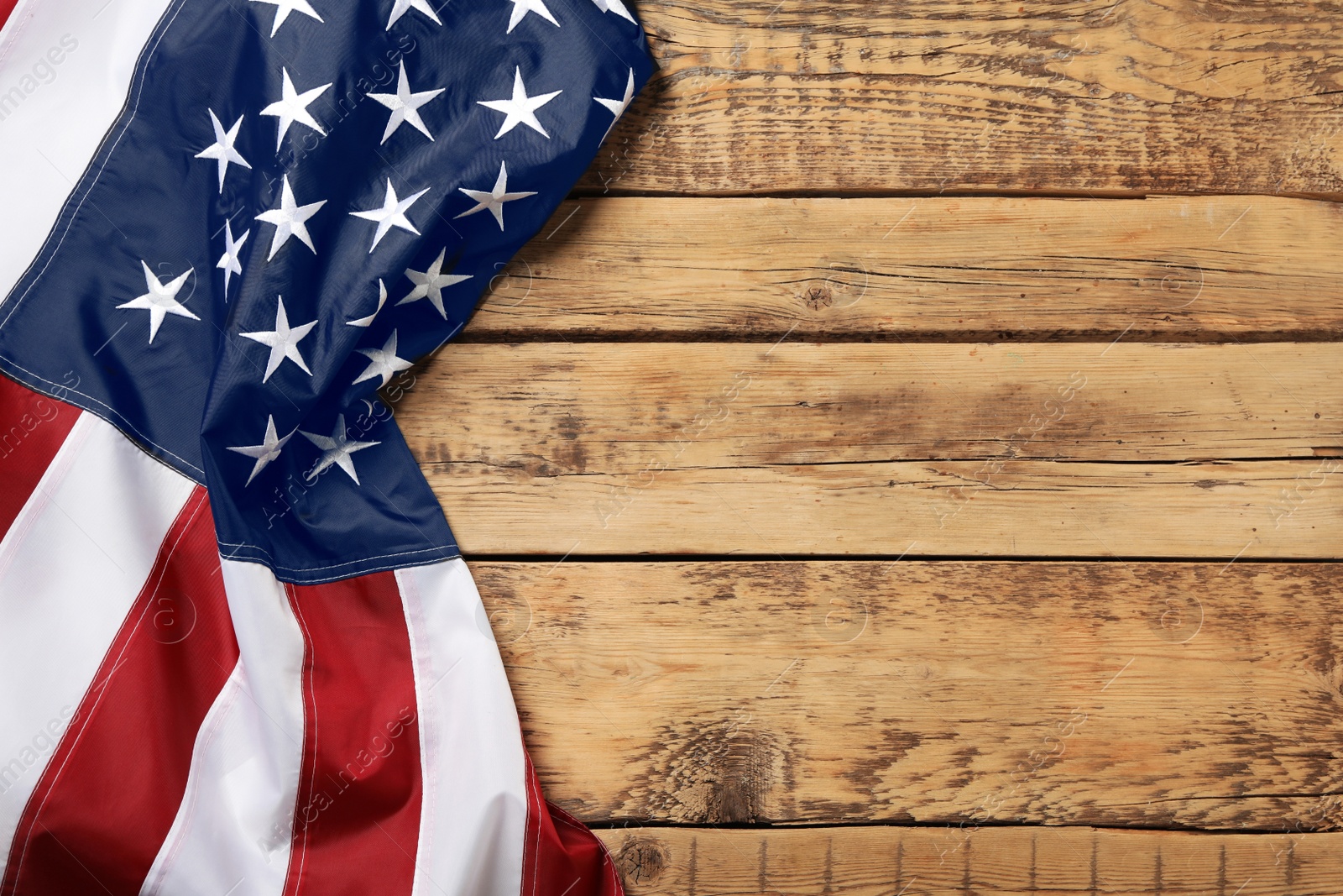 Photo of American flag on wooden table, top view with space for text. Memorial Day