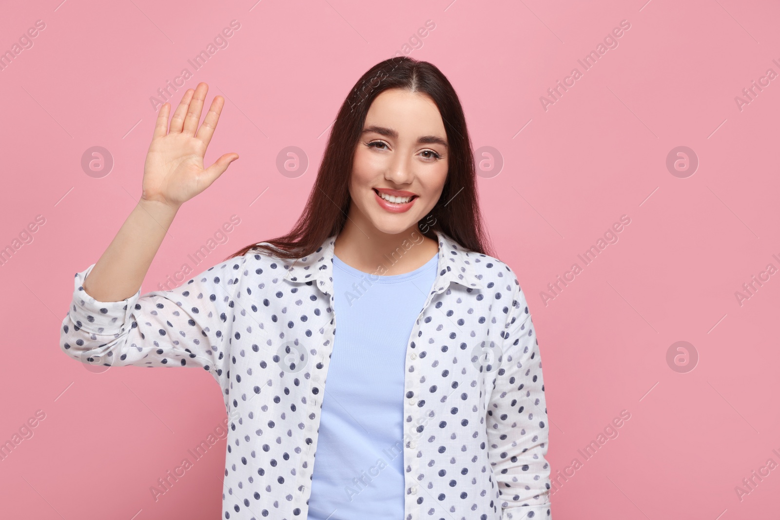 Photo of Happy woman giving high five on pink background