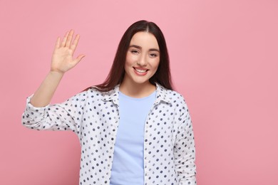 Photo of Happy woman giving high five on pink background
