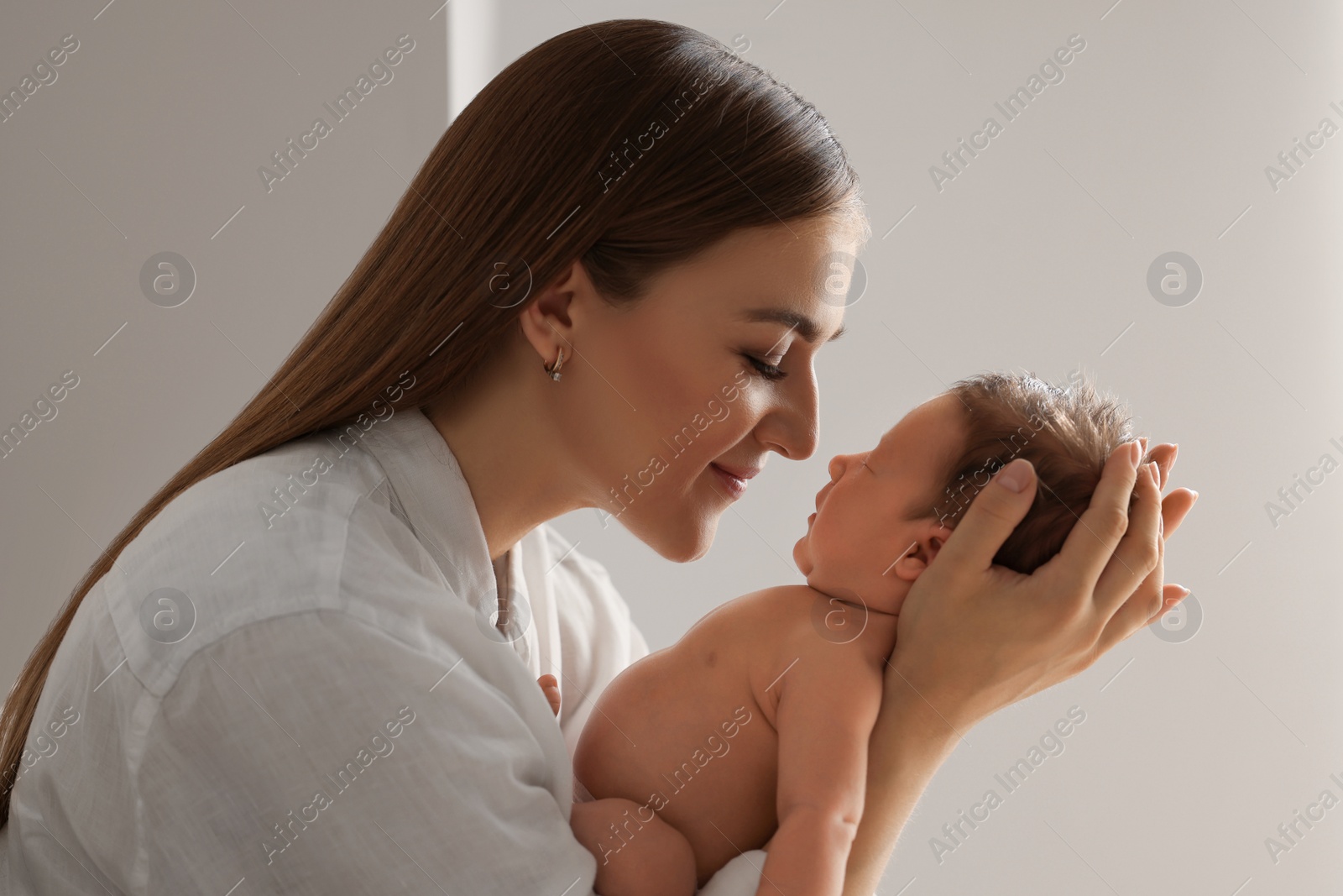 Photo of Mother holding her cute newborn baby indoors