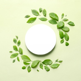 Photo of Flat lay composition with blank card and spring green leaves on color background. Space for text