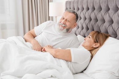 Mature couple together in bed at home