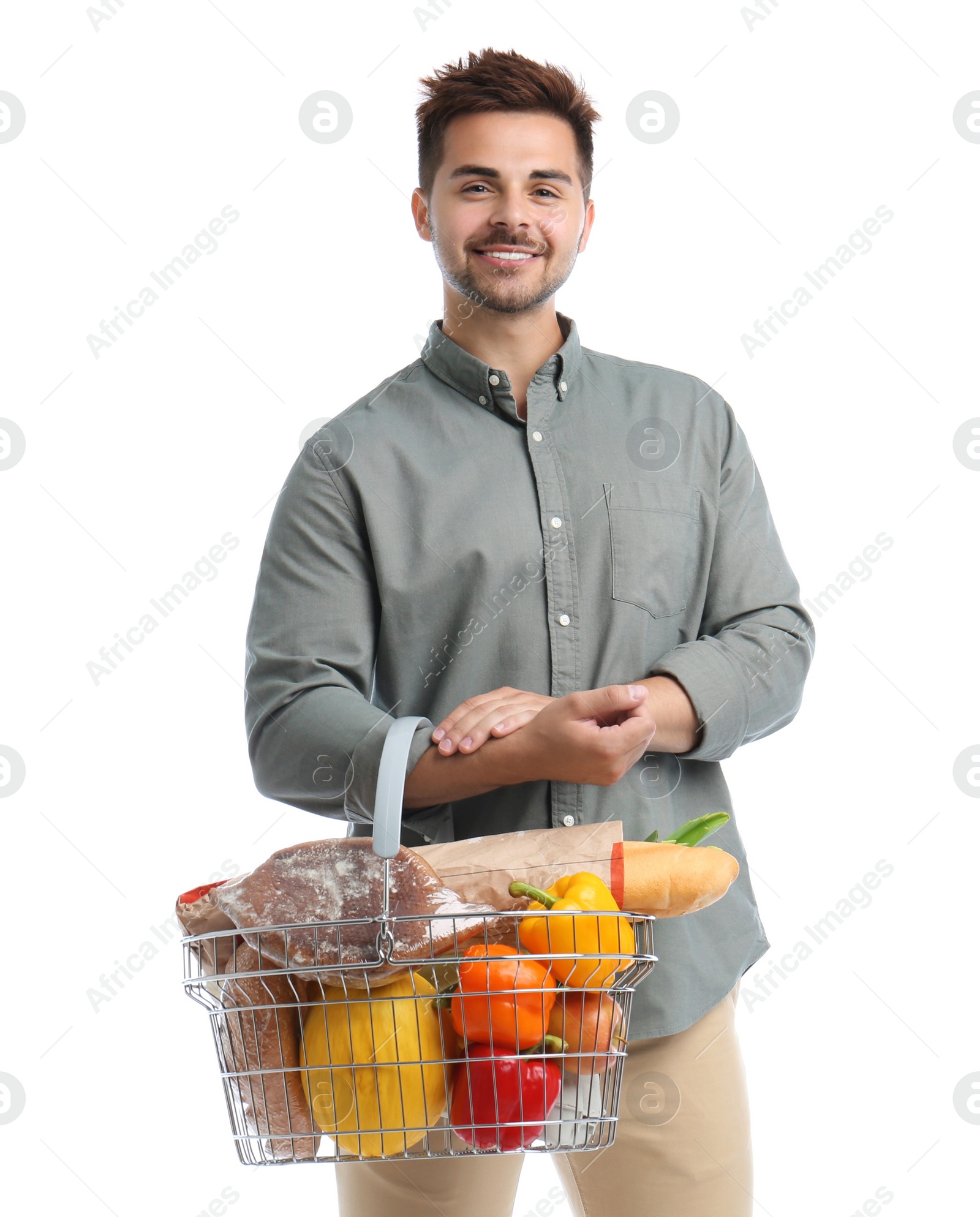 Photo of Young man with shopping basket full of products isolated on white