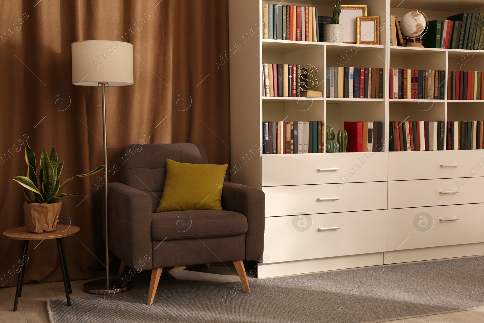 Photo of Cozy home library interior with collection of different books on shelves and comfortable place for reading