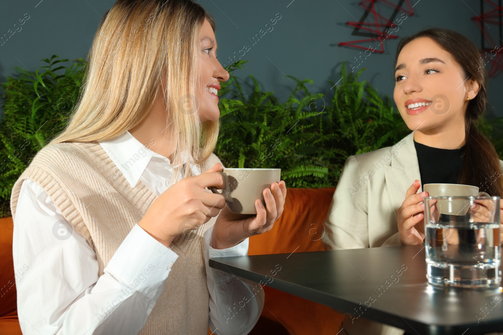 Photo of Friends with drinks spending time together in cafe