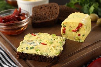 Photo of Tasty butter with green onion, chili pepper and rye bread on table, closeup