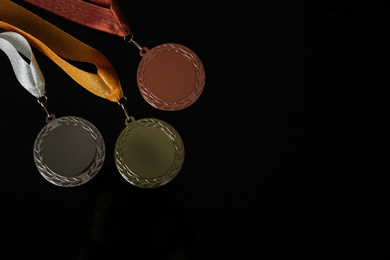 Photo of Gold, silver and bronze medals on black background, flat lay. Space for design