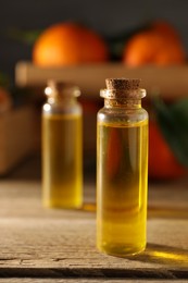 Photo of Bottles of tangerine essential oil on wooden table