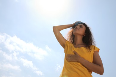 Photo of African-American woman with cold pack suffering from heat stroke outdoors