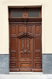 Entrance of house with beautiful wooden door and transom window