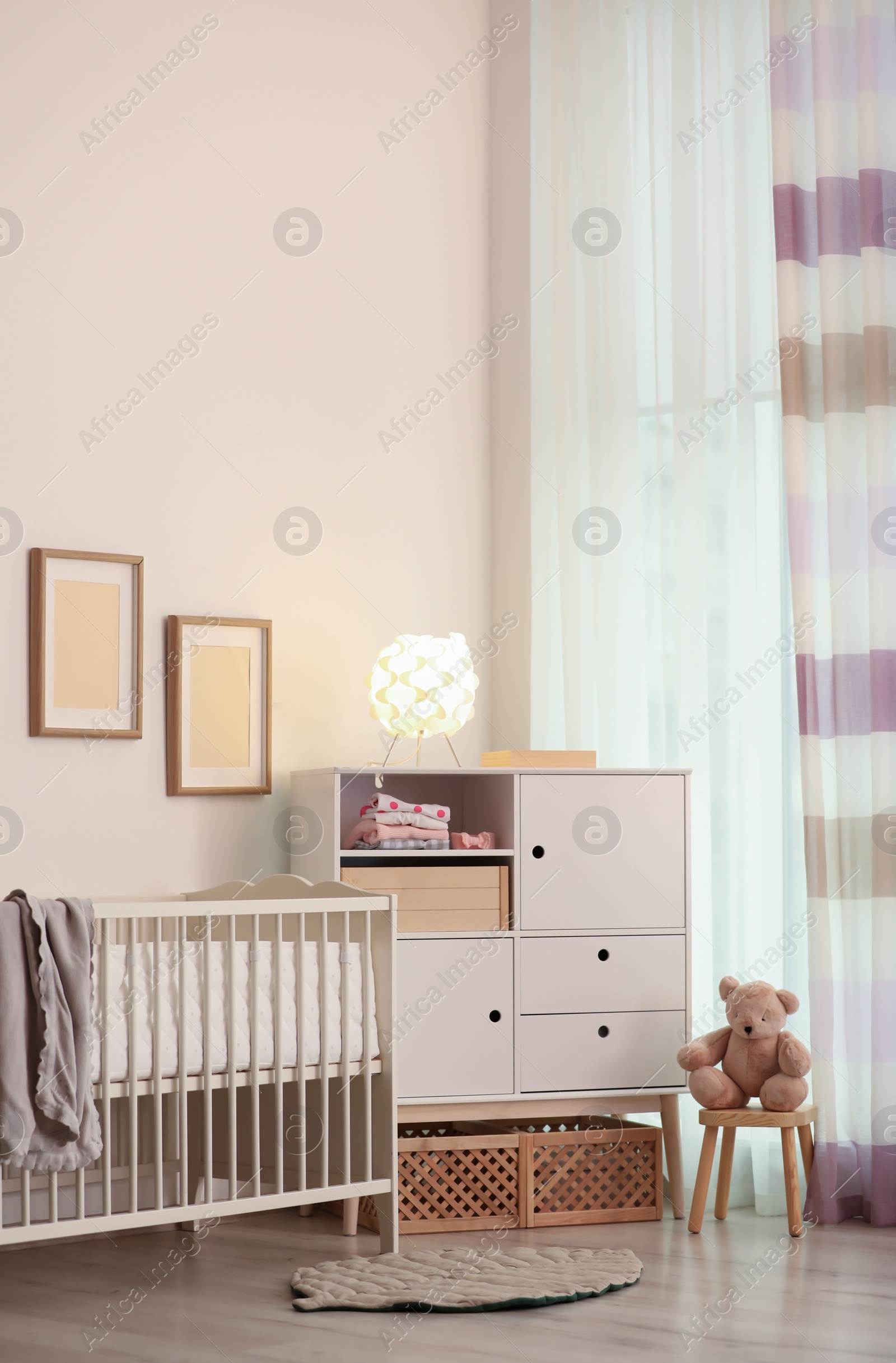 Photo of Modern room interior with crib and wooden crates under cupboard. Eco style