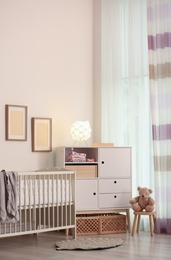 Modern room interior with crib and wooden crates under cupboard. Eco style