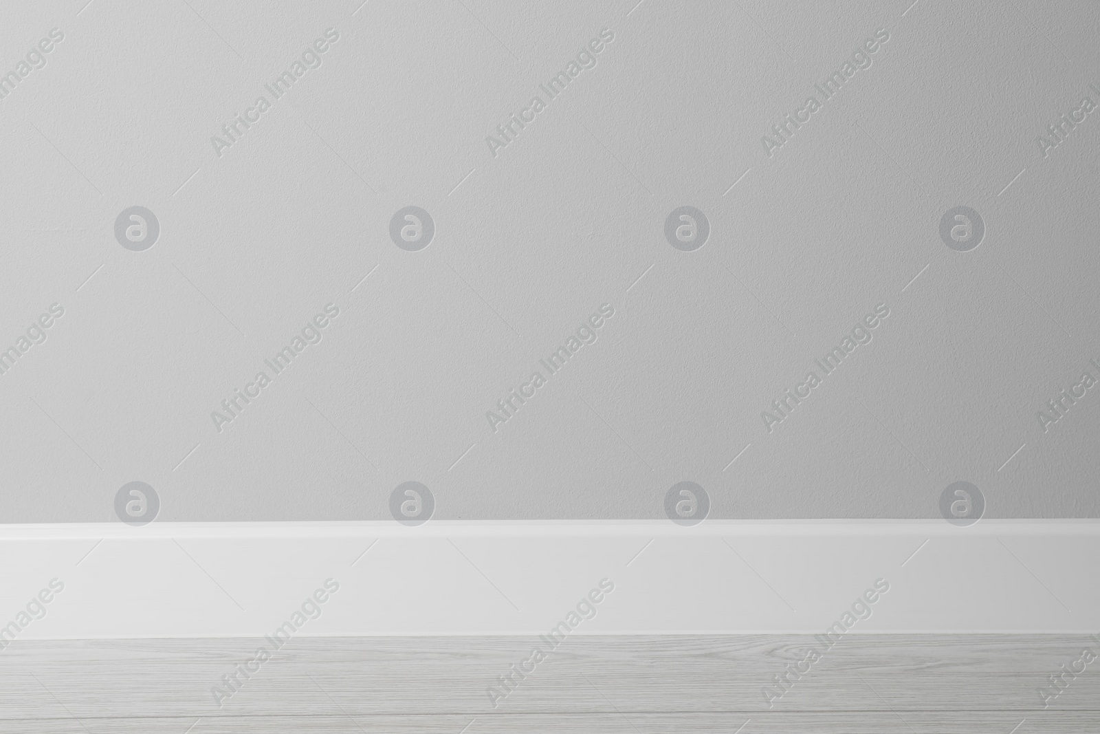 Photo of White plinth on laminated floor near wall indoors