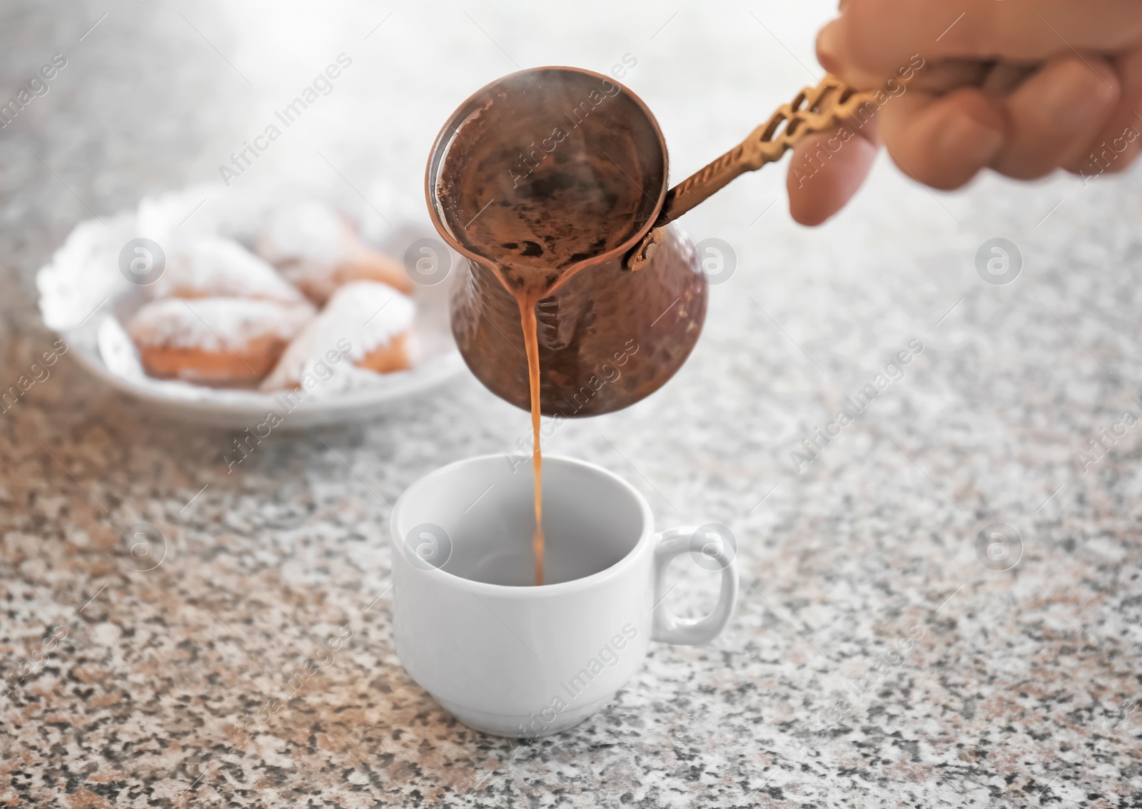 Photo of Woman pouring aromatic coffee into cup on table