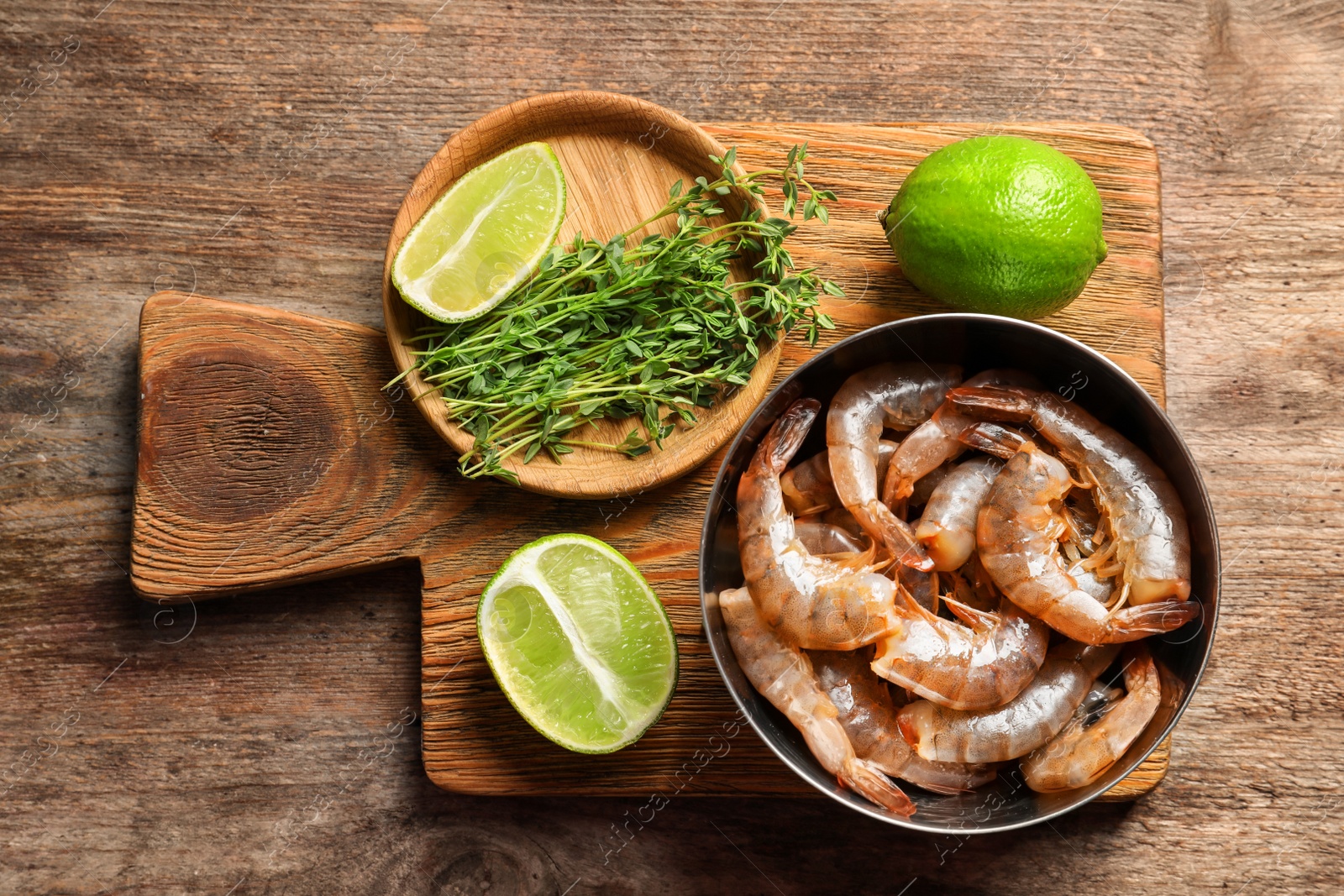 Photo of Bowl with fresh shrimps on wooden board