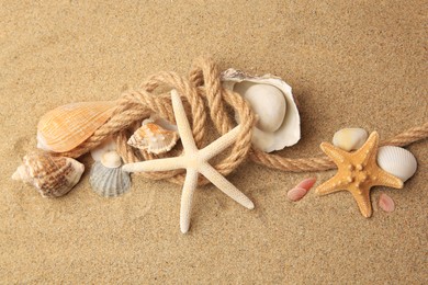 Beautiful sea stars, shells and rope on sand, above view